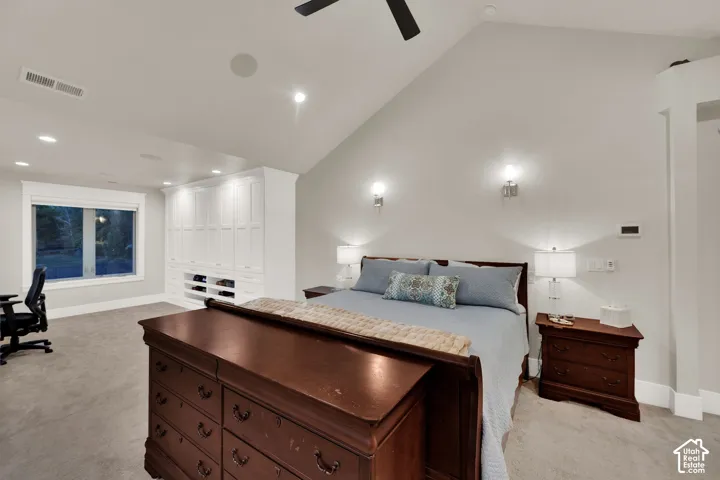 Primary Bedroom. Vaulted ceiling with a ceiling fan, recessed lighting, built-in cabinetry, and wall-mounted sconces