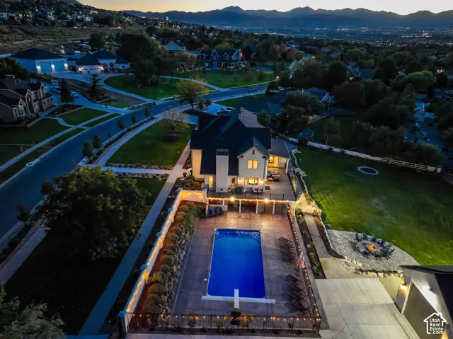 Expansive exterior featuring a swimming pool with diving board, patio area, fire pit, and attached garage