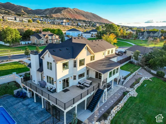 Exterior featuring a multi-level deck with black railings, a dedicated space for outdoor seating, and a covered patio area