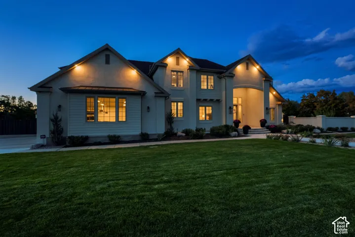 Two-story exterior with a stucco and siding finish, prominent gables, covered entry, and expansive front lawn