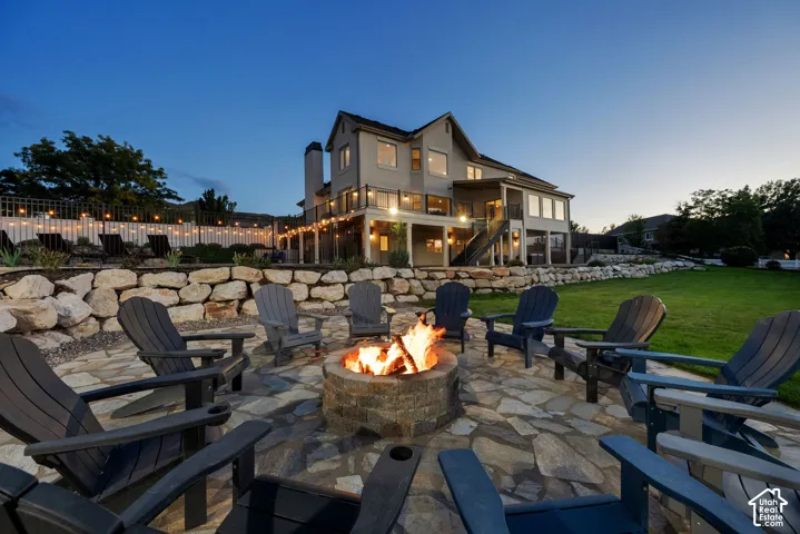 Extensive backyard featuring a stone fire pit, flagstone patio, and terraced landscaping with a retaining wall
