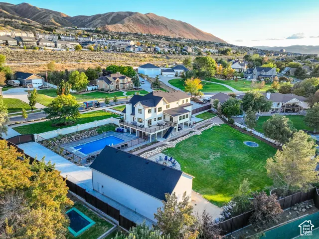 Contemporary residence featuring multiple decks, an outdoor pool, expansive lawn, and a separate auxiliary building