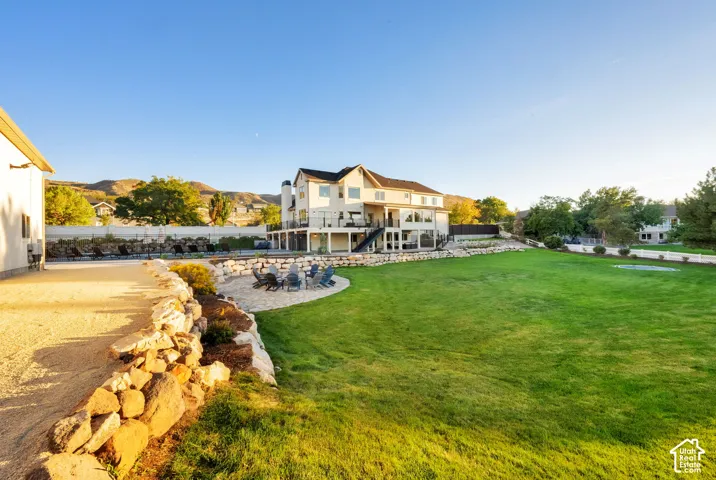 Expansive lawn with a terraced retaining wall, lower-level patio, and upper-level deck