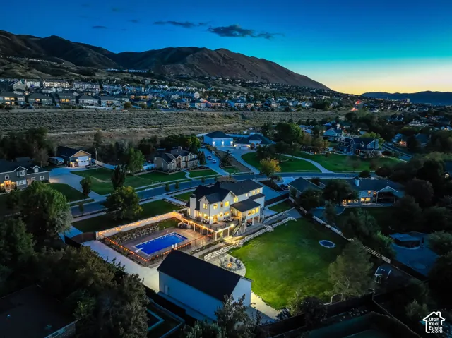 Expansive grounds with a luminous in-ground pool, elevated outdoor patio, and a separate structure