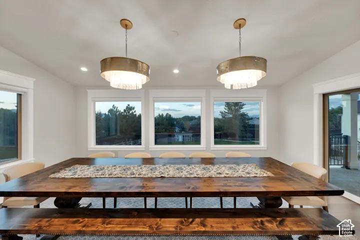 Multiple windows, recessed lighting, and two tiered drum chandeliers