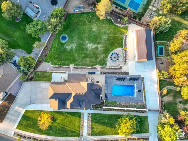 Expansive grounds featuring a swimming pool, stone patio, large lawn areas, and a detached structure