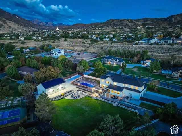 Expansive property featuring a main residence, detached accessory building, swimming pool with surrounding patio, tennis/pickleball courts, and mature landscaping