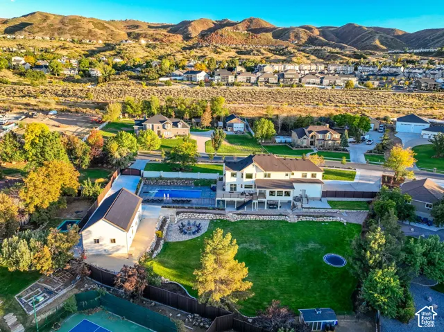 Extensive property featuring a main residence, detached ancillary structure, full-size tennis court, and an in-ground swimming pool