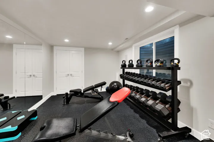 Recessed lighting illuminates the space, featuring white paneled double doors and a window with white trim
