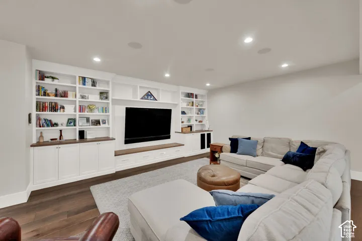 Built-in entertainment center with open shelving, integrated cabinetry, and wood-finish countertops