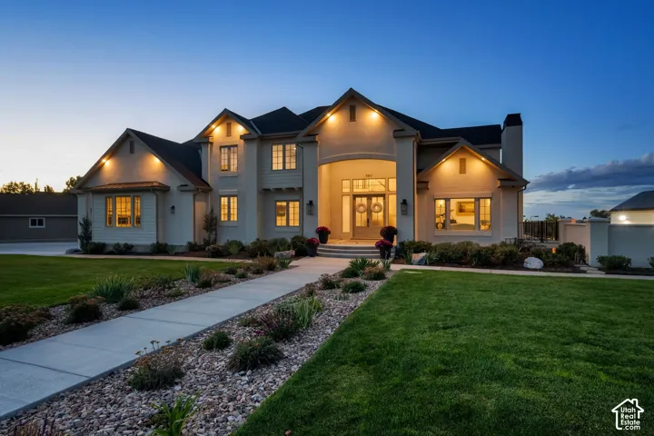 Two-story stucco and siding exterior with multiple gables, arched entry, and dark roof