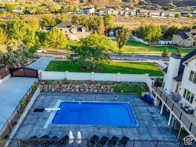 Expansive backyard with an in-ground swimming pool, stamped concrete decking, and a raised rock garden