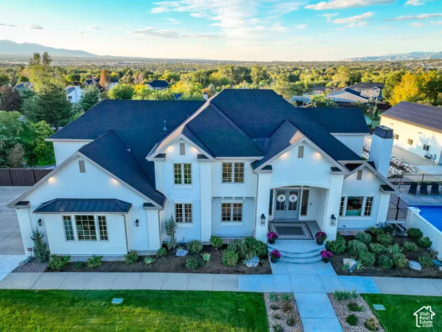 White exterior with dark roof, integrated landscaping, and an outdoor pool