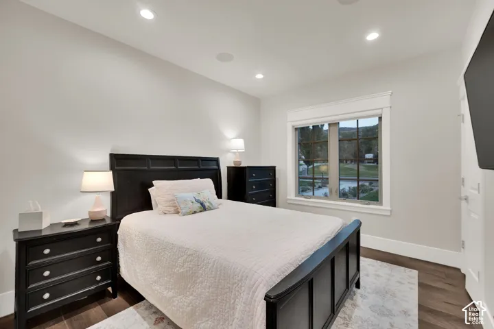 Bedroom/Office on main floor.  Recessed ceiling lighting, dark wood-finish flooring, white window trim, and white wall finishes