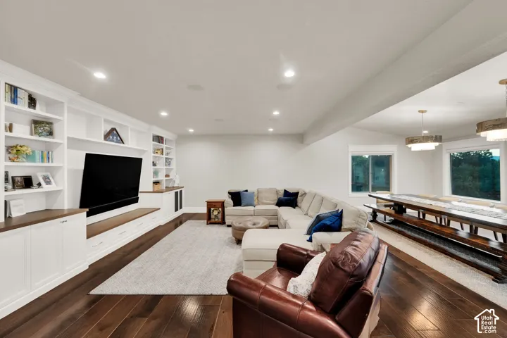 Hardwood flooring throughout, recessed ceiling lighting, built-in shelving, white trim, and ample natural light