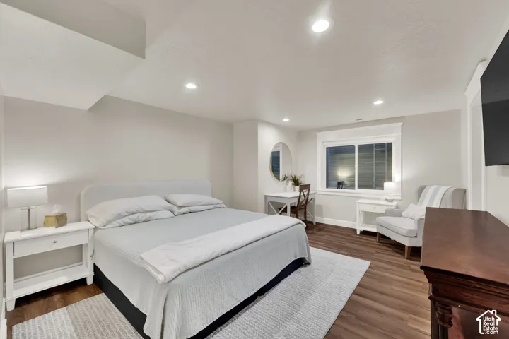 Recessed lighting, wood-finish flooring, and a window with blinds