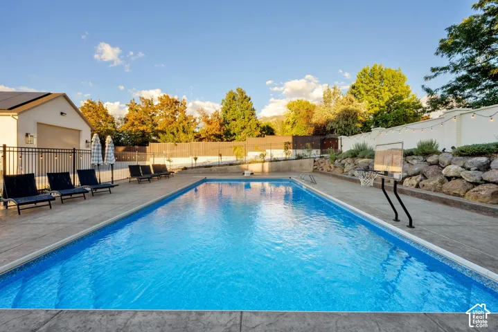 Expansive inground swimming pool with surrounding stamped concrete patio