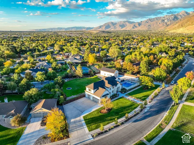 Two-story residence with a multi-car driveway, an in-ground swimming pool, and an expansive lawn