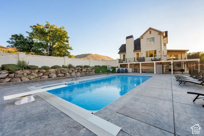 Expansive outdoor pool with a diving board, surrounded by stamped concrete decking