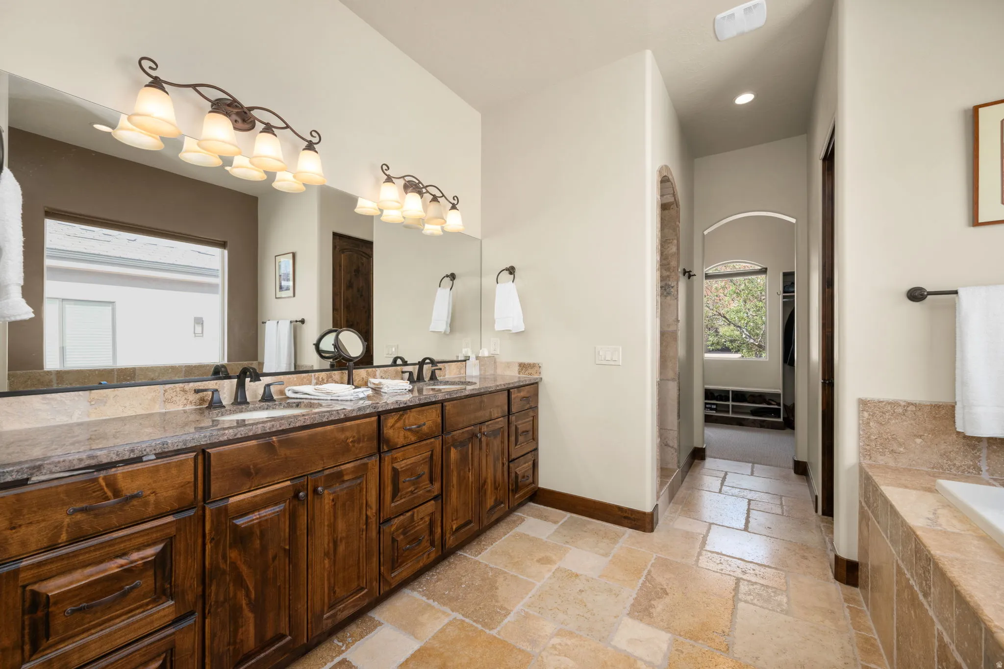 Double vanity featuring stone countertops and integrated sinks