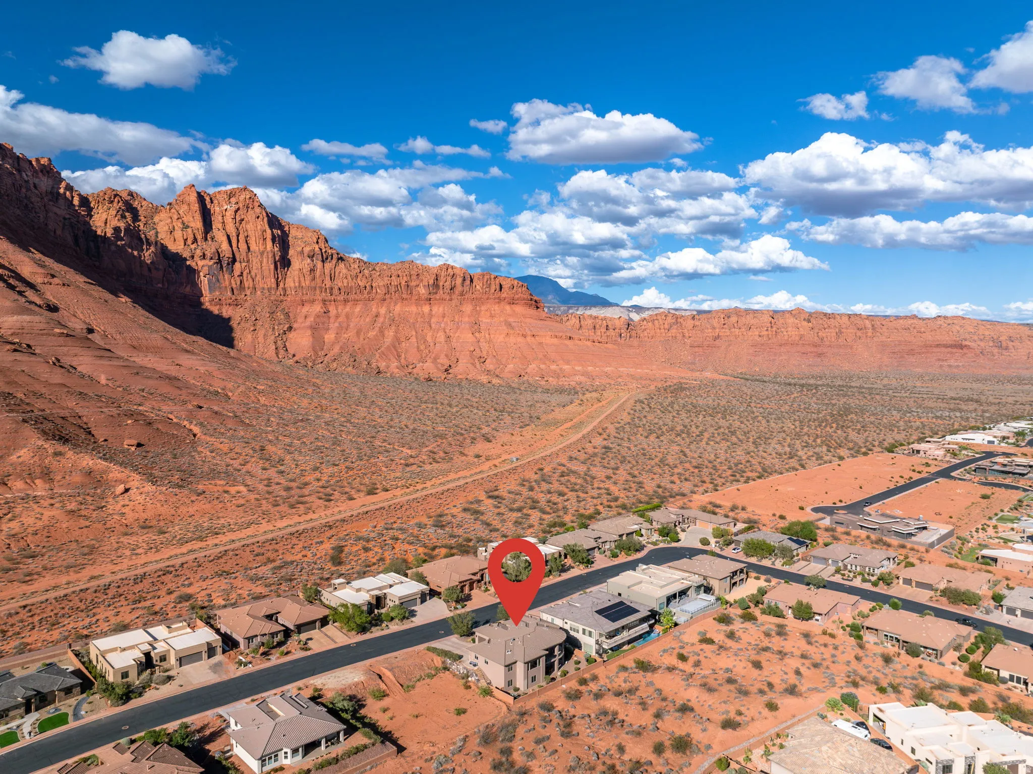 Residential property set against a prominent red rock formation