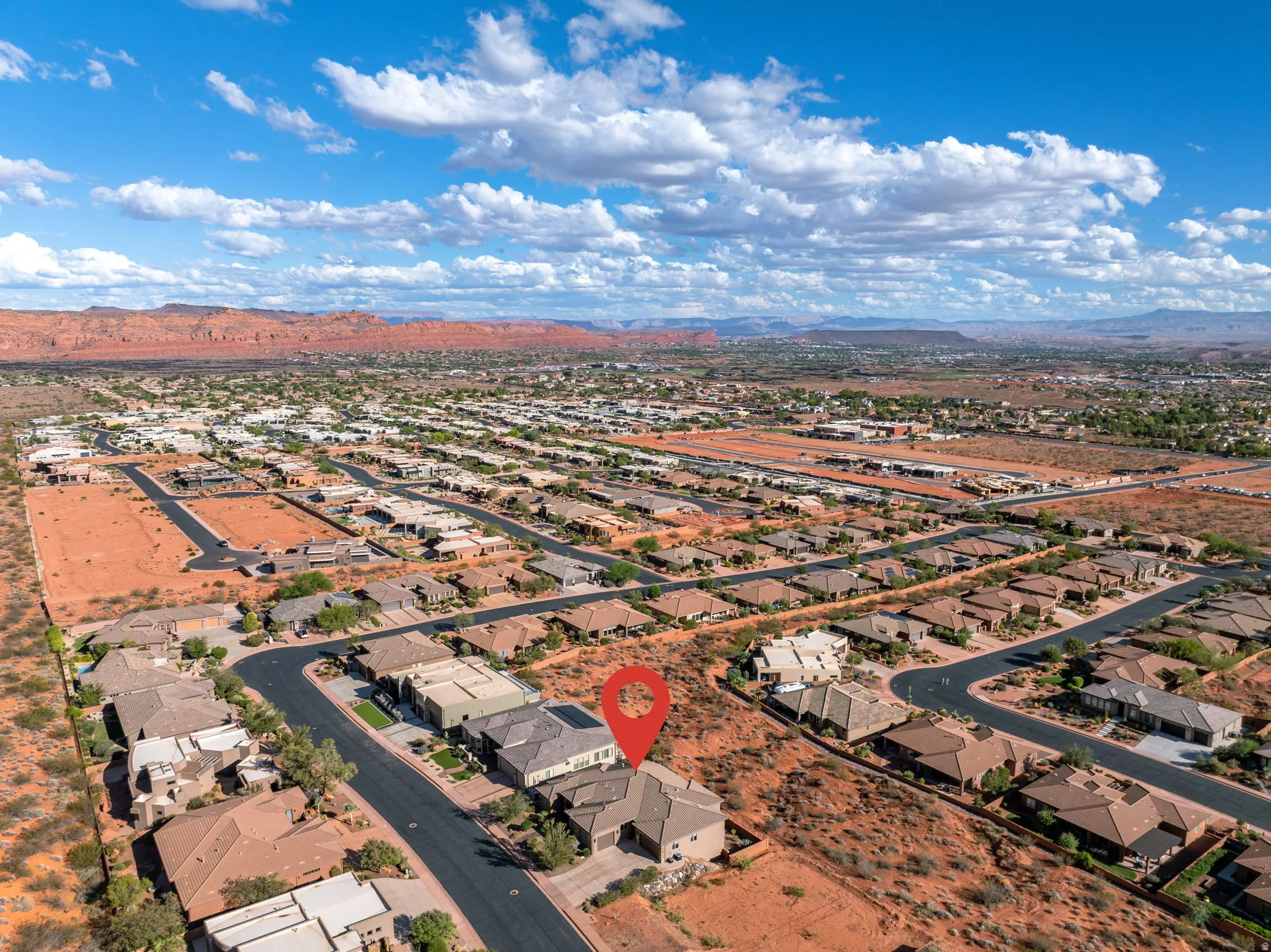 Aerial perspective highlighting a residential neighborhood with surrounding desert landscape and distant mountains