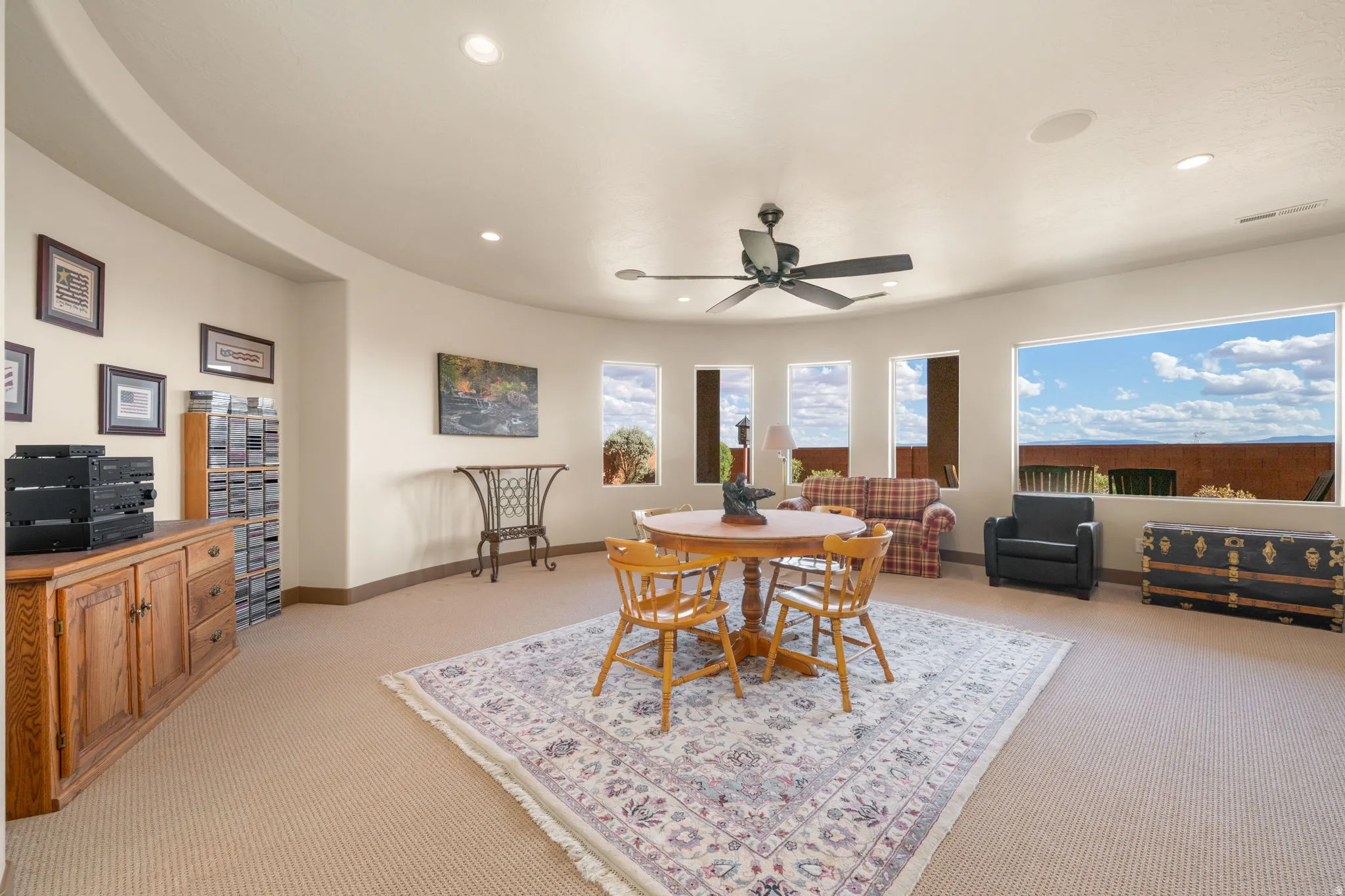 Curved wall architecture featuring recessed lighting and a ceiling fan
