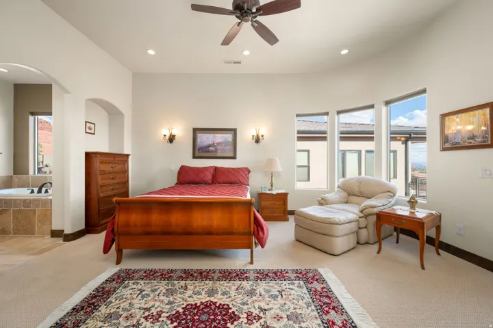 Primary Bedroom. Recessed lighting, ceiling fan, arched doorway, and built-in soaking tub with tile surround
