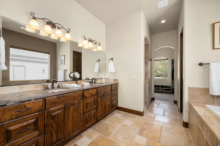 Double vanity featuring stone countertops and integrated sinks