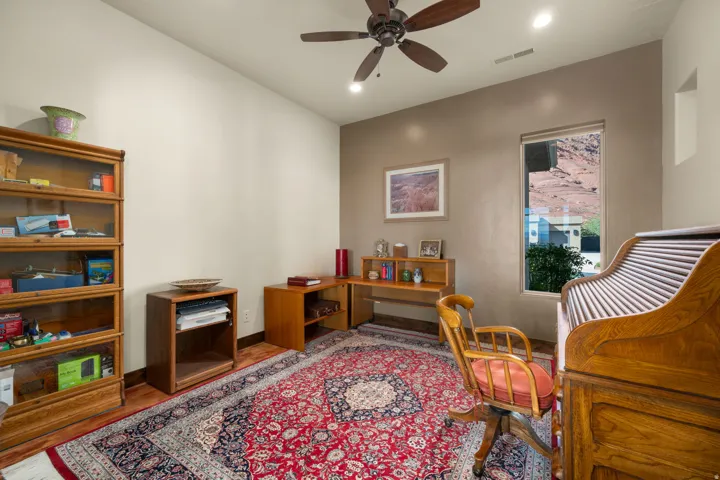 Recessed lighting, wood-finish flooring, ceiling fan, and a tall window with natural scenery