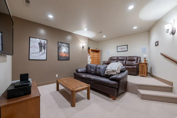 Recessed lighting illuminates the carpeted floor and accent wall