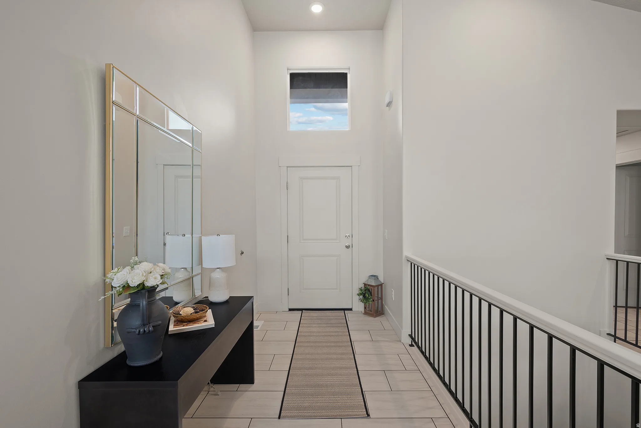 Two-story foyer with high ceilings, transom window, recessed lighting, and tile flooring