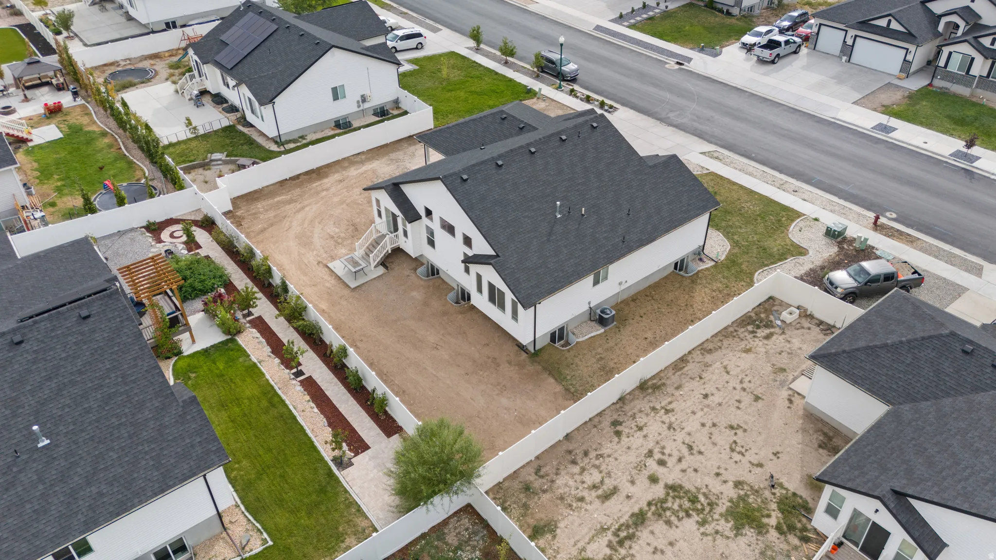 Two-story residence with a dark shingle roof, white siding, and a rear deck with stairs