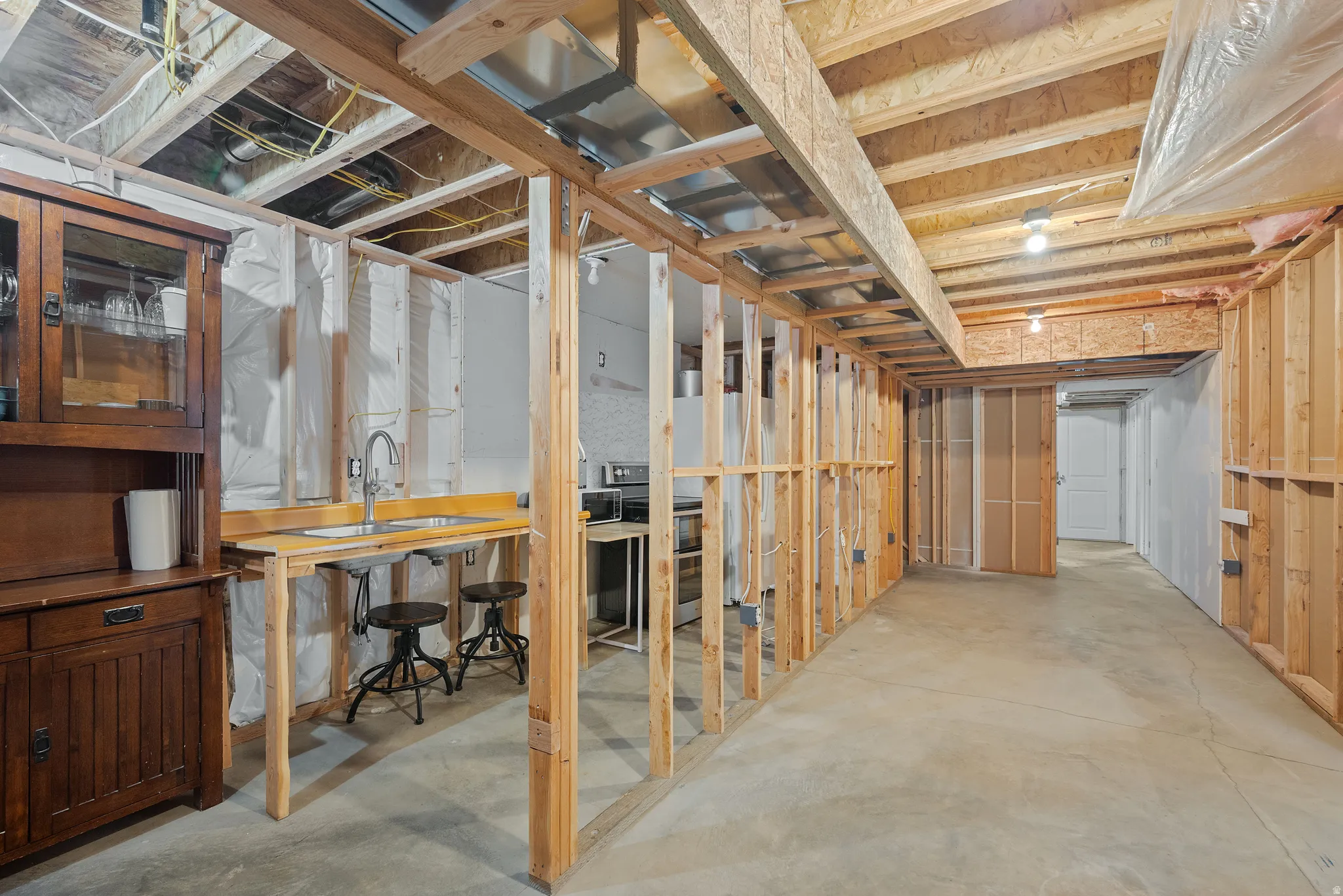Framed basement space featuring a built-in sink and concrete flooring