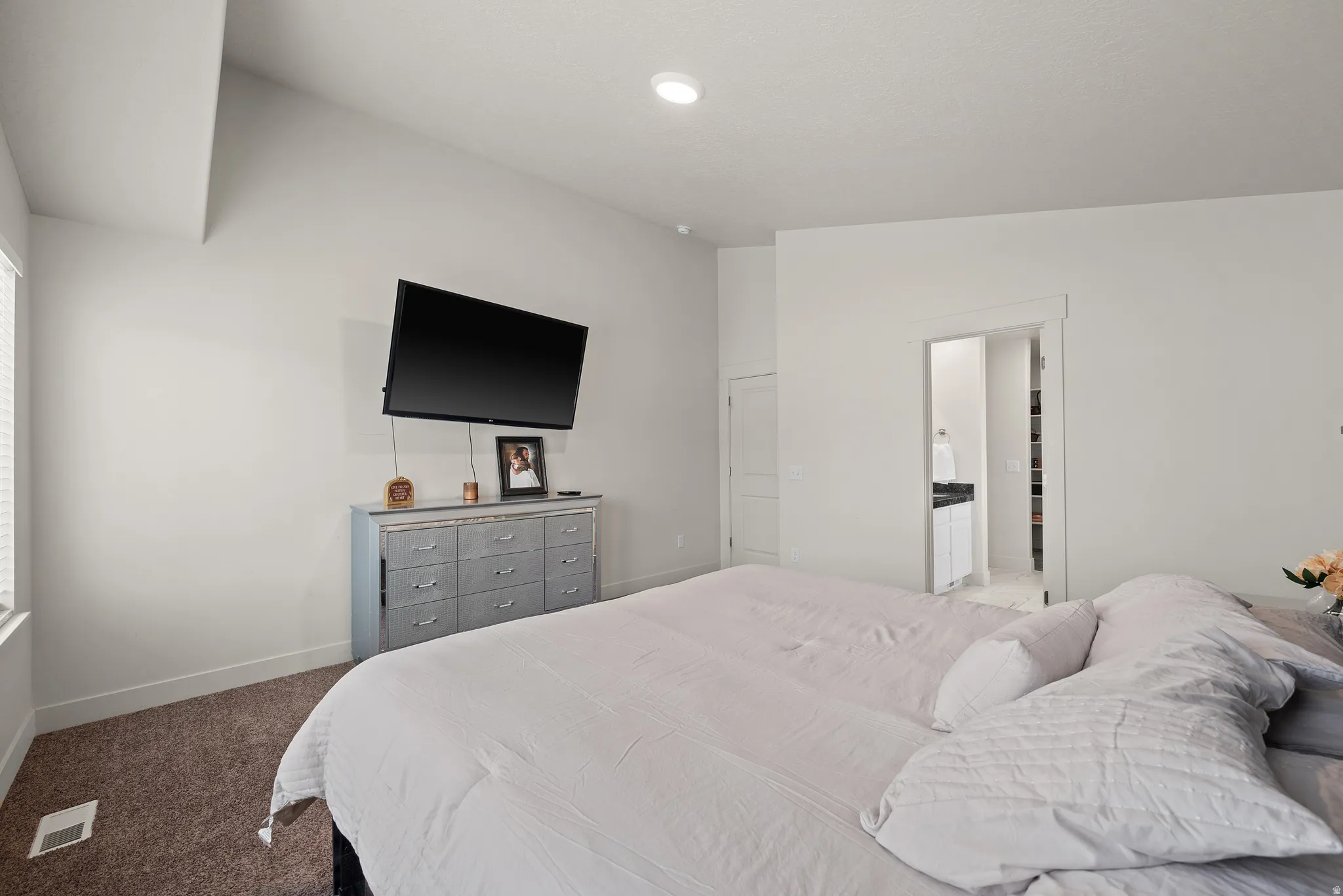 Vaulted ceiling, recessed lighting, and a window with blinds
