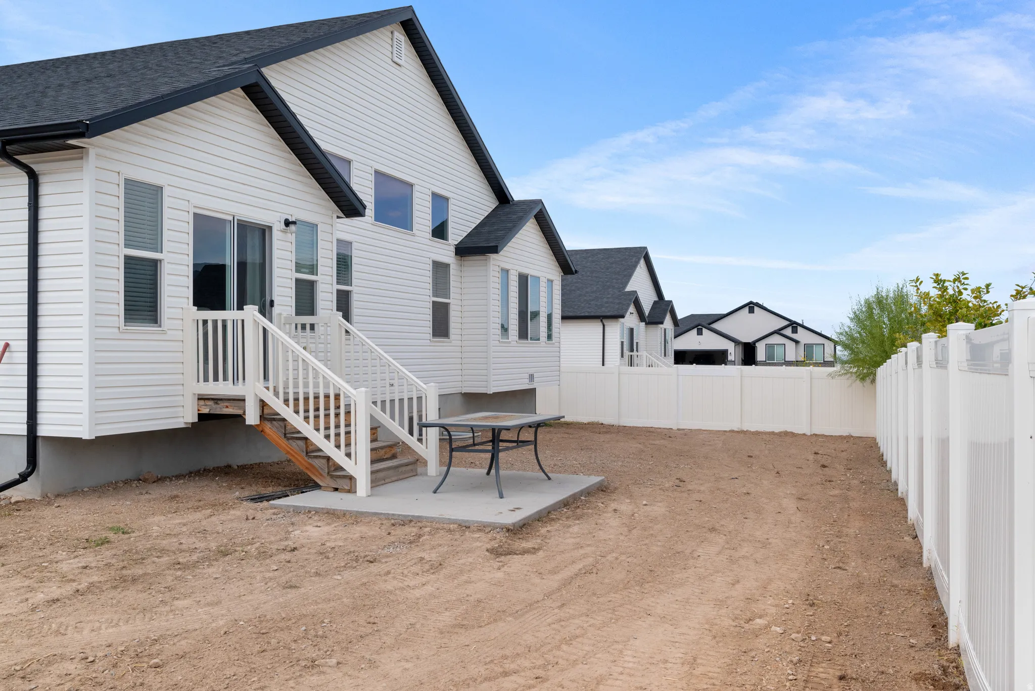 White vinyl siding exterior with black trim accents and a dark shingled roof