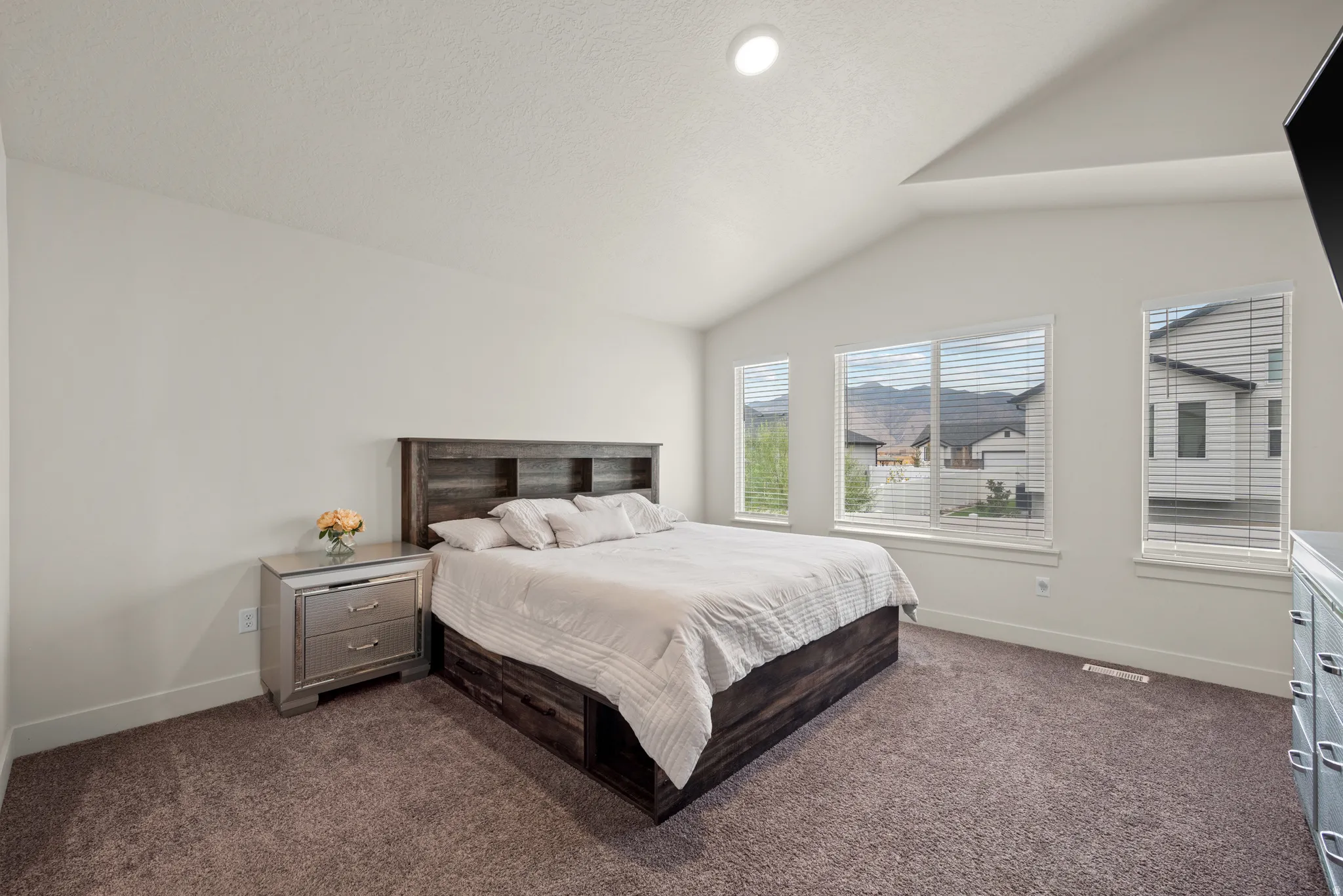 Vaulted ceiling bedroom with recessed lighting, wall-to-wall carpeting, and multiple windows