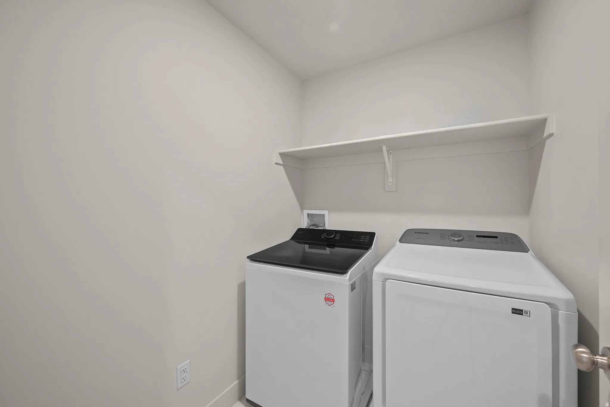 Dedicated laundry area with a white wall-mounted shelf