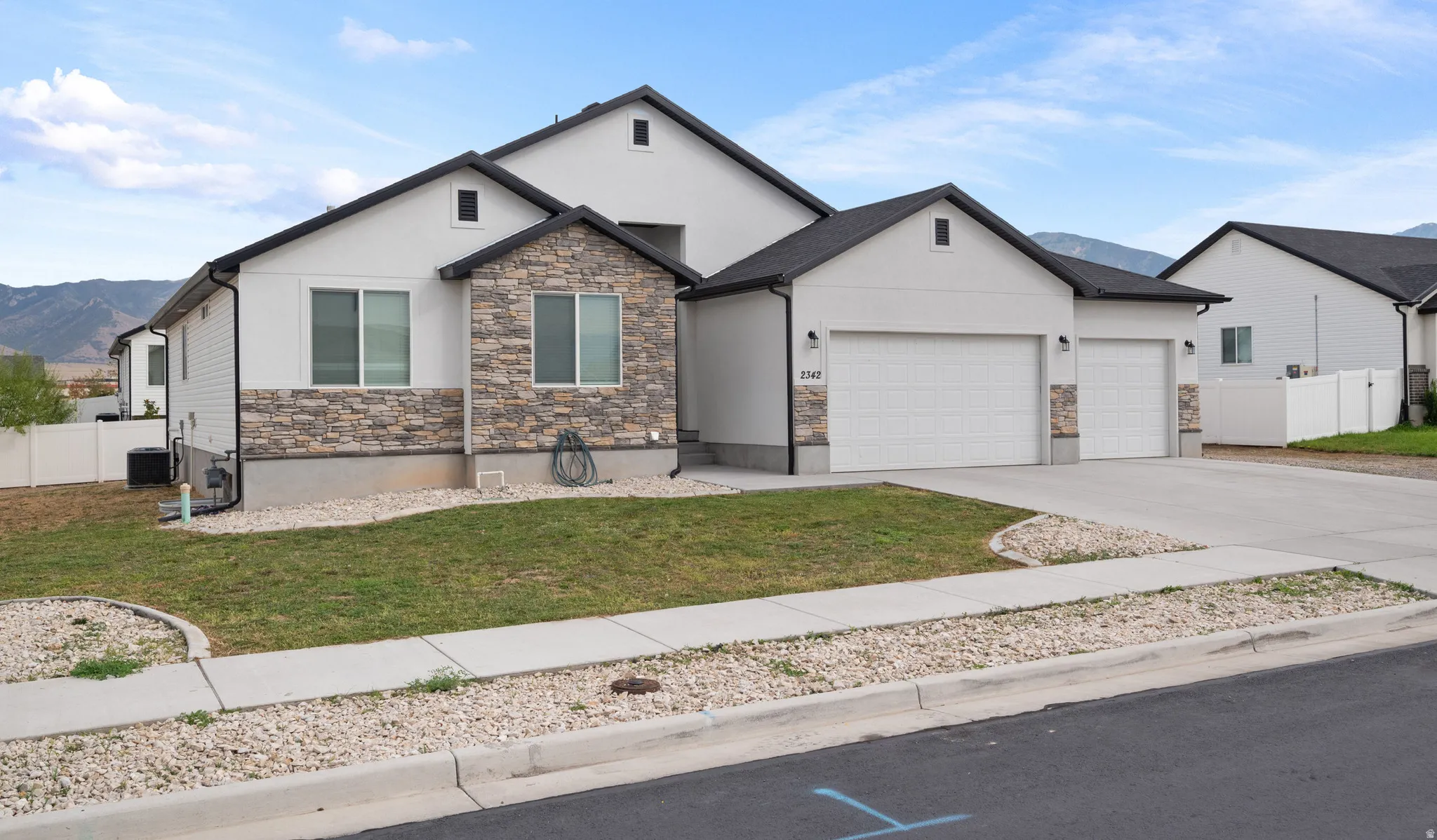 Contemporary exterior featuring light-colored stucco and natural stone accents