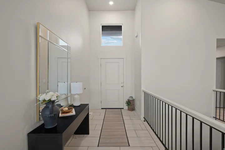 Two-story foyer with high ceilings, transom window, recessed lighting, and tile flooring