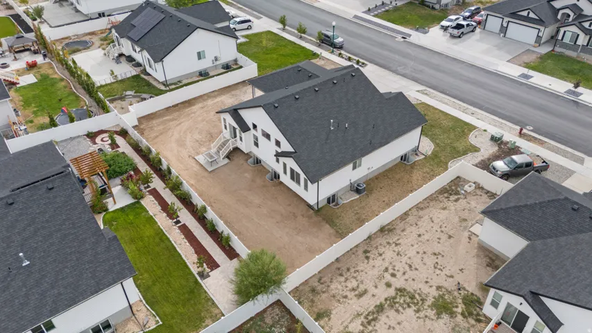 Two-story residence with a dark shingle roof, white siding, and a rear deck with stairs