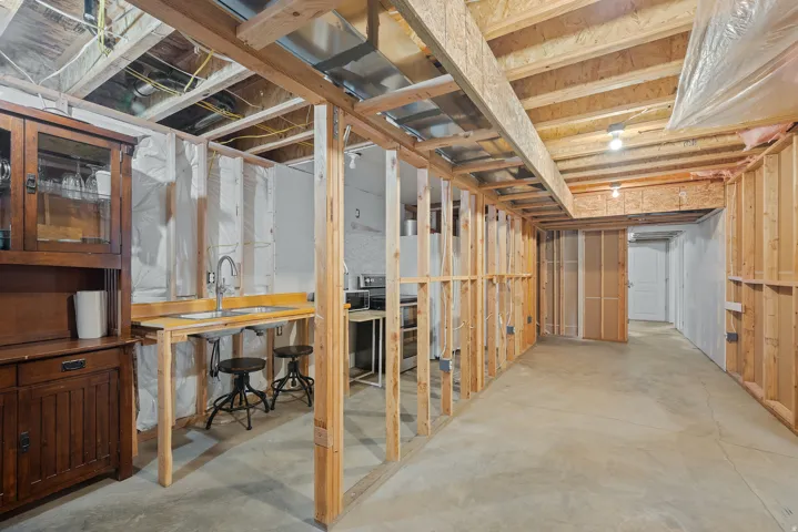 Framed basement space featuring a built-in sink and concrete flooring