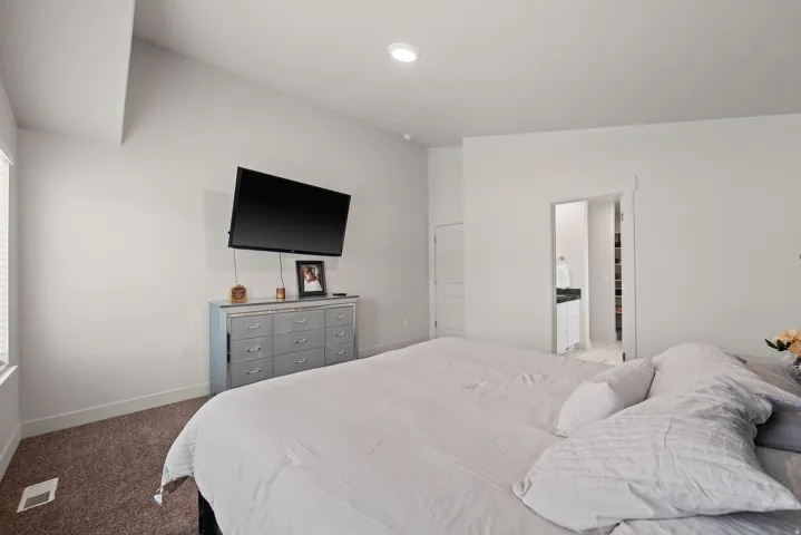 Vaulted ceiling, recessed lighting, and a window with blinds