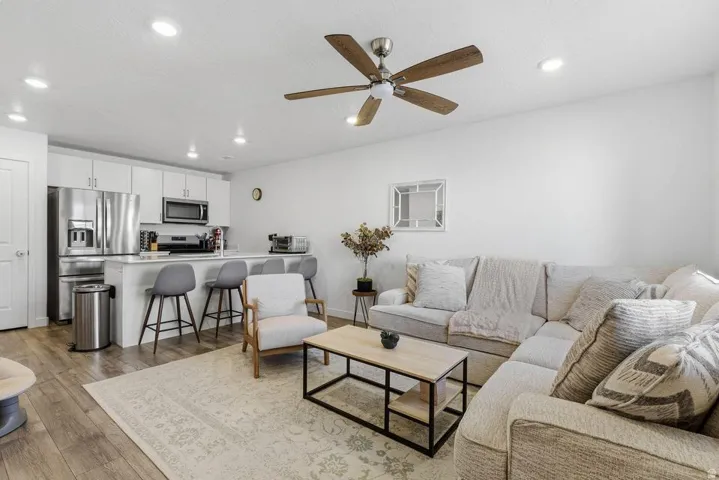 Open-concept living space featuring wood-finish flooring, recessed lighting, and a ceiling fan