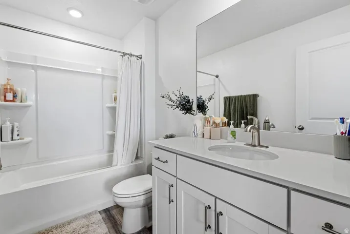 White vanity with an integrated sink, brushed nickel faucet, and a large wall-mounted mirror