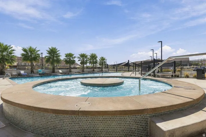 Spa with mosaic tile surround, integrated steps, and stainless steel handrails