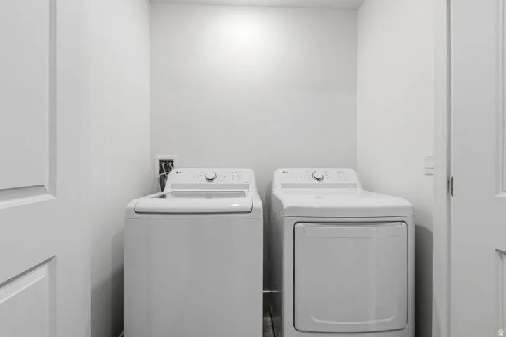 Dedicated laundry area with a white top-load washing machine and white front-load dryer
