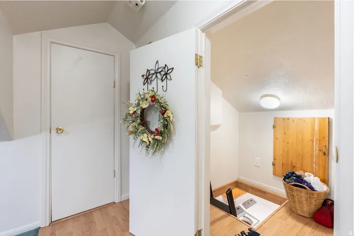 Recessed utility space with wood-finish flooring and a flush-mount ceiling light