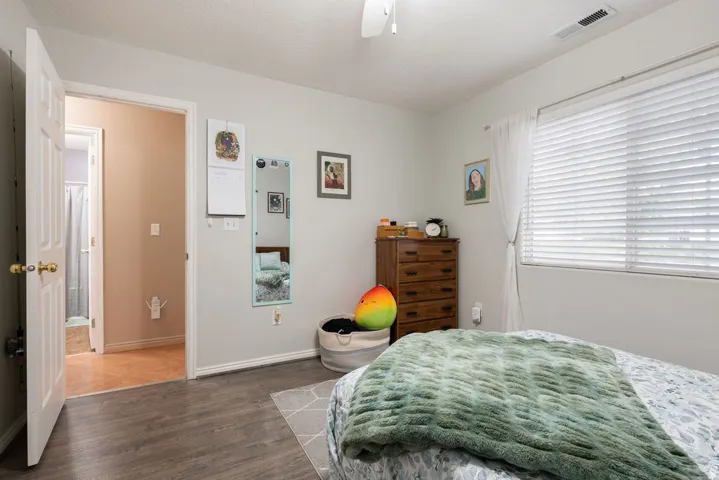 Wood-finish flooring throughout, with a window featuring horizontal blinds