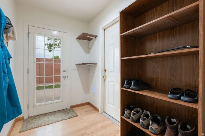 Wood-finish flooring, full-lite door with grid, and built-in shelving